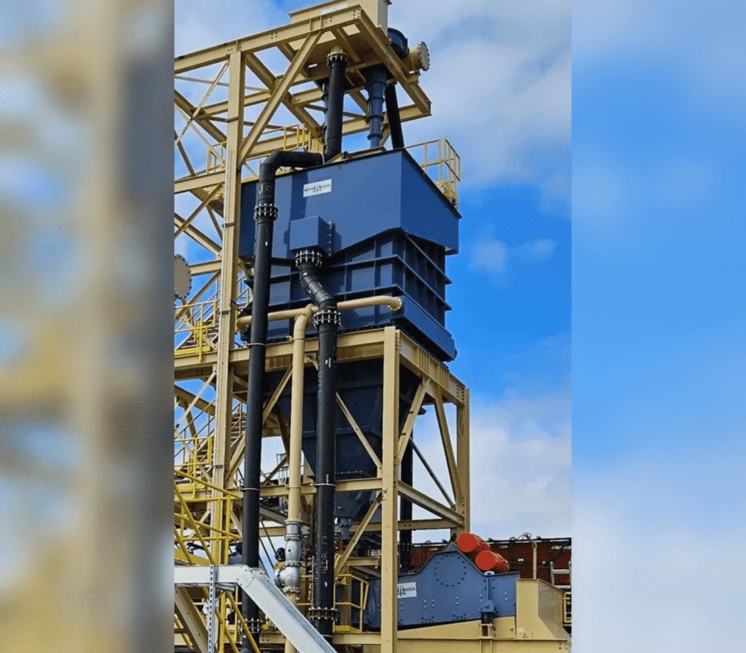 A large blue machine is on top of a yellow structure.