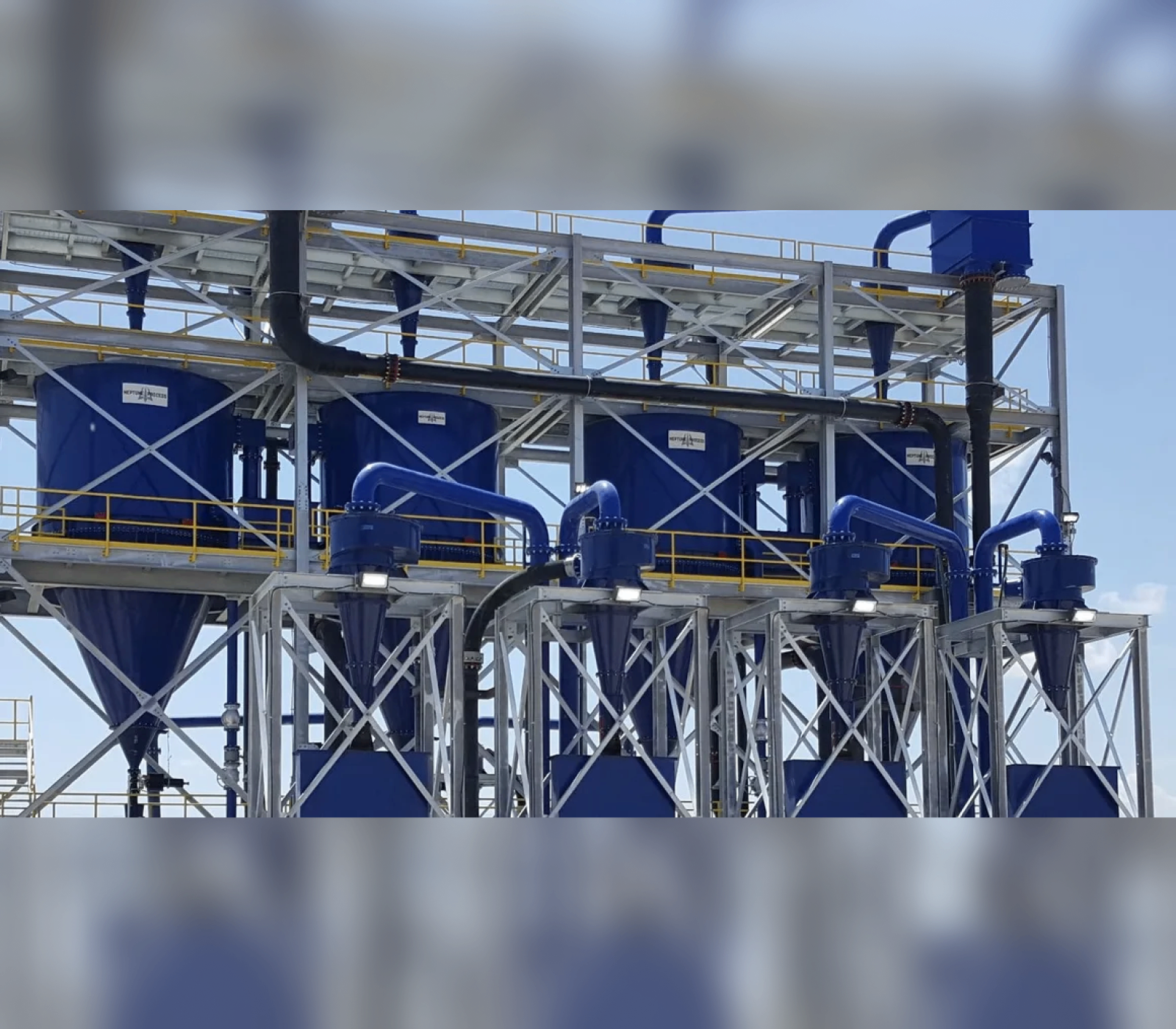 A large blue machine is in the middle of a factory.
