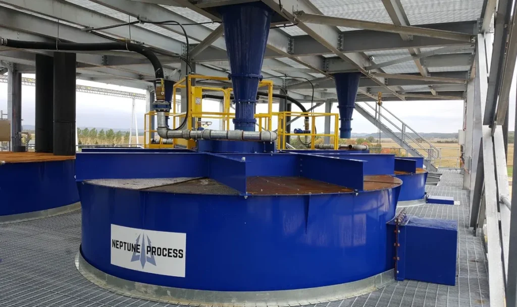 A large blue tank with many pipes on top of it.