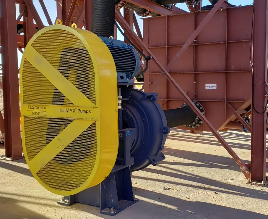 A yellow and blue pump sitting on top of concrete.